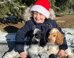 Nathan assis avec des chiots sur les genoux